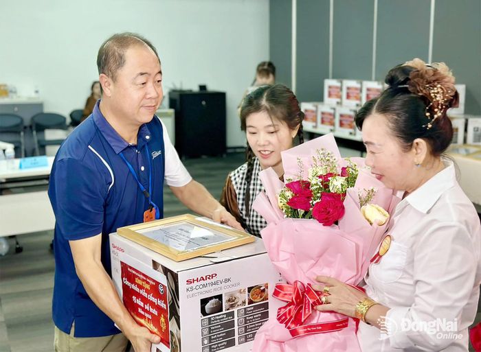 Đại diện Công ty TNHH Pou Sung Việt Nam tặng hoa và quà tri ân người lao động. Ảnh: N.Hòa