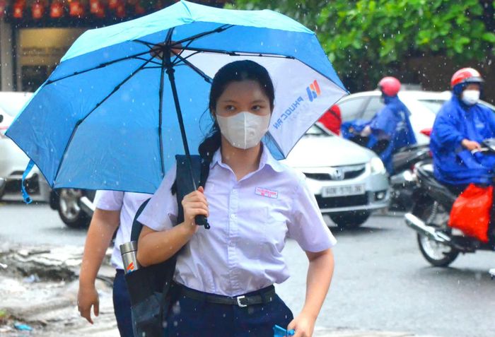 Thí sinh đến dự thi môn chuyên tại Trường THPT chuyên Lương Thế Vinh chiều 29-5 trong cơn mưa nặng hạt. Ảnh: CN