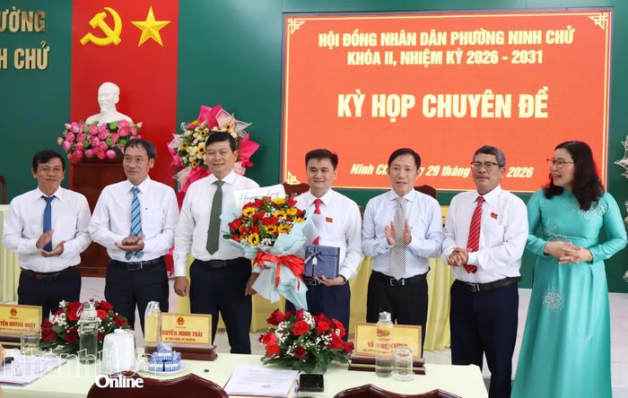 Ông Nguyễn Quang Nhật và lãnh đạo phường Ninh Chử tặng hoa và quà cho ông Vũ Ngọc Đương.