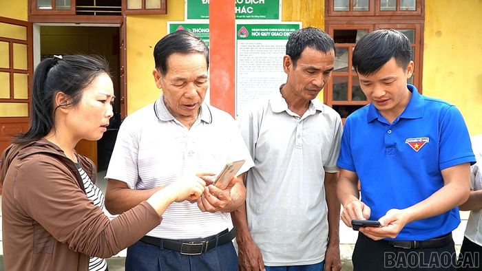 Cán bộ xã Xuân Ái hỗ trợ Nhân dân trong công tác chuyển đổi số.