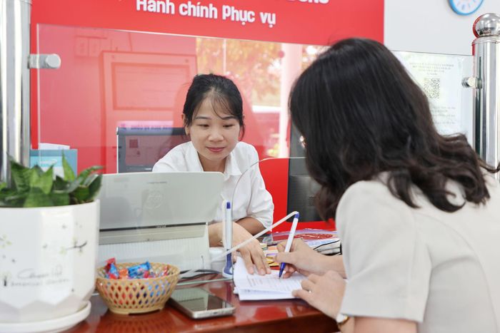 Nhân viên Trung tâm Phục vụ hành chính công hỗ trợ người dân ghi thông tin khi đến làm thủ tục