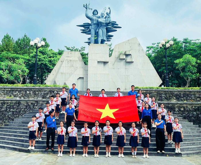 Giáo viên, học sinh Trường tiểu học Hàm Nghi tổ chức hoạt động hát quốc ca tại "địa chỉ đỏ" - Ảnh: Q.H