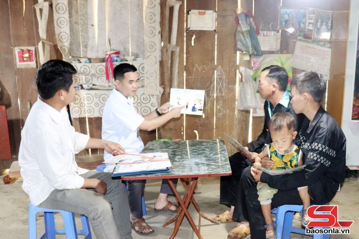 Cán bộ Trạm Y tế xã Bó Sinh tuyên truyền, hướng dẫn người dân phòng chống dịch bệnh. 