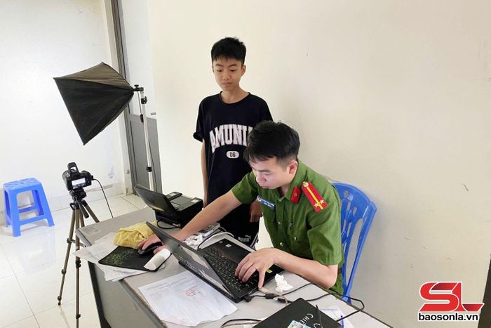 Cán bộ Công an phường Chiềng Sinh thu nhận hồ sơ căn cước, cấp tài khoản định danh điện tử cho học sinh.