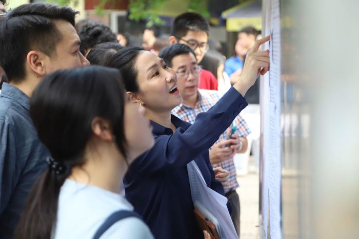 Phụ huynh và học sinh kiểm tra số báo danh cho con trước giờ thi, đảm bảo thông tin dự thi chính xác.