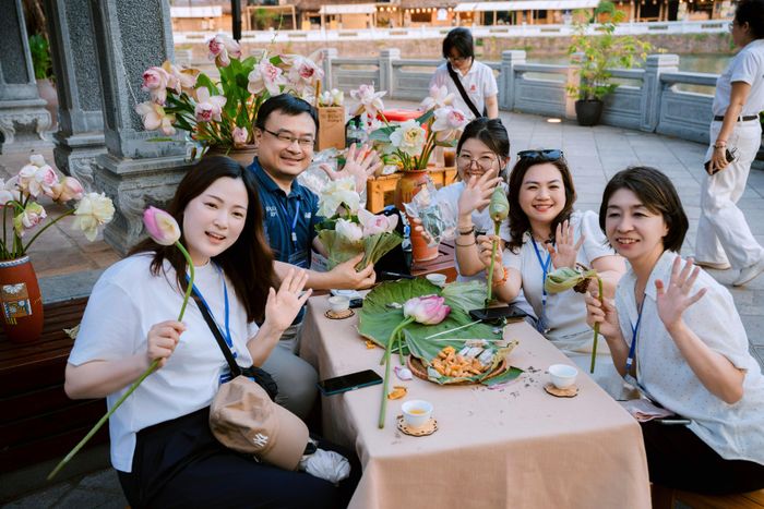 Các thành viên đoàn Farmtrip tìm hiểu và trải nghiệm làm trà sen Hà Nội. Ảnh: BTC