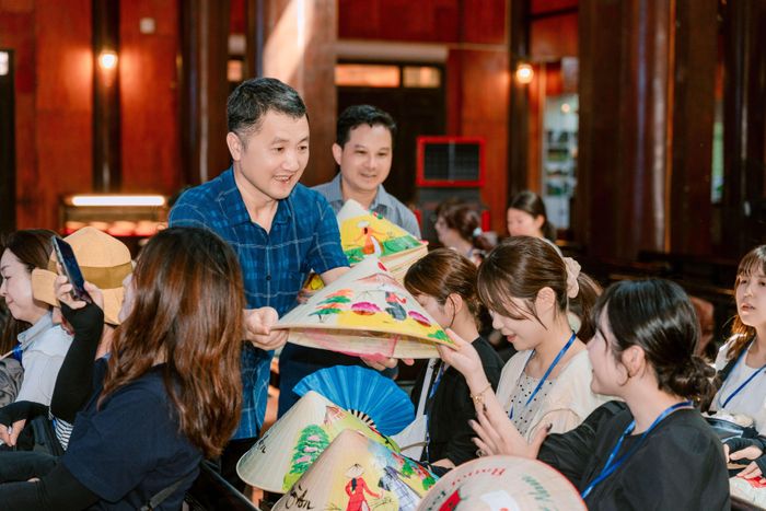 Giám đốc Sở Du lịch Ninh Bình Bùi Văn Mạnh tặng nón lá Việt Nam cho các thành viên đoàn farmtrip. Ảnh: BTC