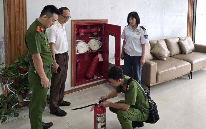Công an phường Võ Cường hướng dẫn người dân sử dụng bình chữa cháy.