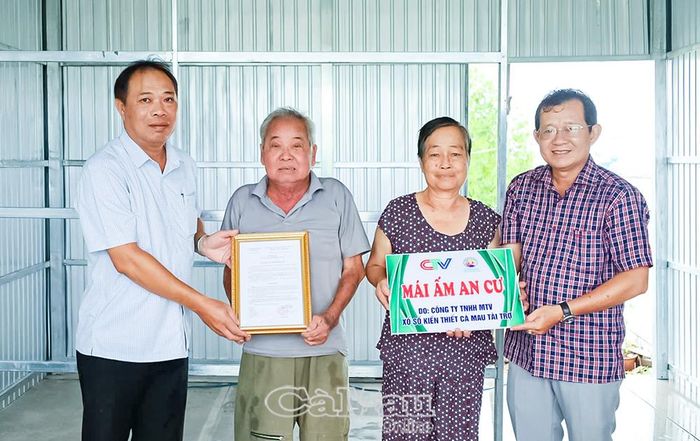 Nhà báo Ngô Minh Toàn, Phó Giám đốc Thường trực Báo và phát thanh, truyền hình Cà Mau (bìa phải), cùng ông Lê Văn Khởi, Chủ tịch Ủy ban MTTQ Việt Nam xã Đất Mới (bìa trái), trao bảng tượng trưng và Quyết định hỗ trợ xây dựng nhà cho ông Tô Văn Xiếu.