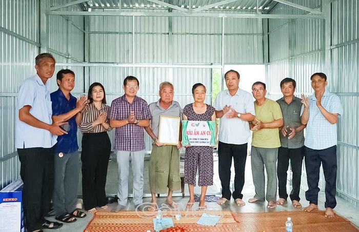 Đại diện chính quyền địa phương, nhà tài trợ và người dân chúc mừng gia đình ông Tô Văn Xiếu có nhà mới.