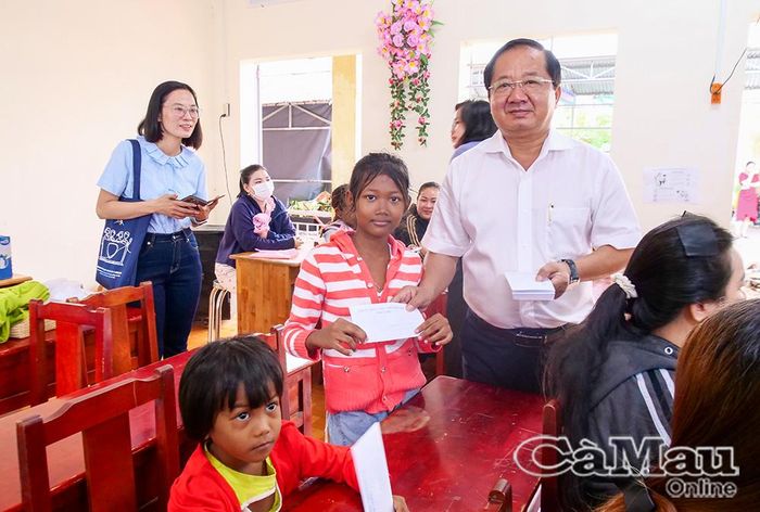 Đồng chí Lê Thanh Triều trao quà cho từng trẻ ở khu lưu cư An Xuyên.