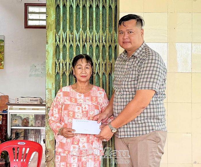  Ông Huỳnh Khánh Duy, Phó Chủ tịch UBND xã U Minh, trao tiền hỗ trợ hộ dân có nhà bị tốc mái.