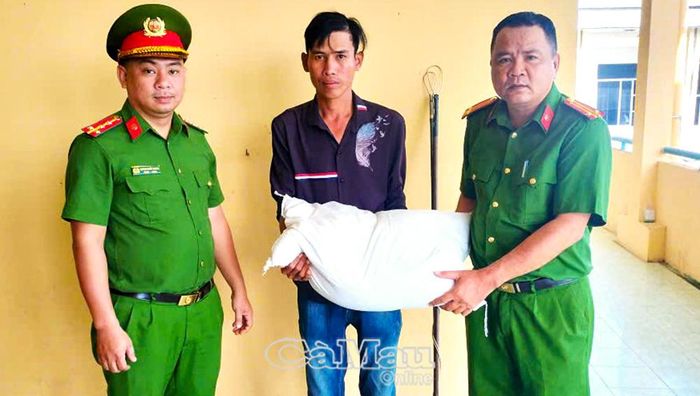 Ông Trần Văn Thương (ở giữa) tự nguyện giao nộp công cụ kích điện và nhận nhu yếu phẩm từ Công an xã Châu Thới.
