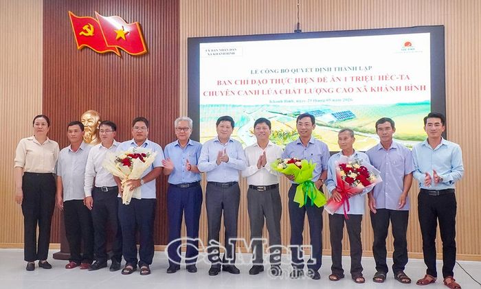 Phó Chủ tịch UBND tỉnh Cà Mau Lê Văn Sử (thứ 6, từ trái sang) tặng hoa chúc mừng Ban Chỉ đạo và Tổ giúp việc thực hiện Đề án tại xã Khánh Bình.