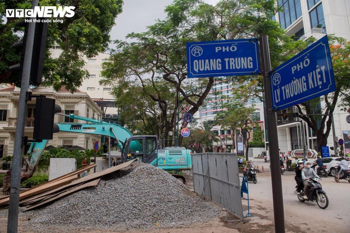 Tại nút giao Quang Trung - Lý Thường Kiệt, đơn vị thi công dựng hàng rào tôn kết hợp lưới B40 theo từng đoạn ngắn để đào hố, lắp đặt tuyến cống hộp mới. 