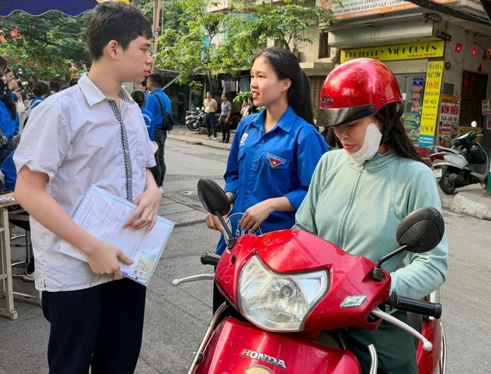 Em Chu Gia Bách được đoàn viên thanh niên hỗ trợ, hướng dẫn trước khi vào làm thủ tục dự thi. Ảnh: Võ Giang