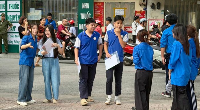 Tình nguyện viên hướng dẫn thí sinh di chuyển tới khu vực cần thiết tại điểm thi. Ảnh: Võ Giang