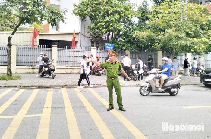 Lực lượng Công an phường Kiến Hưng hướng dẫn, phân luồng giao thông bảo đảm an toàn tại điểm thi Trường THCS Phú La. Ảnh: Tuấn Điệp