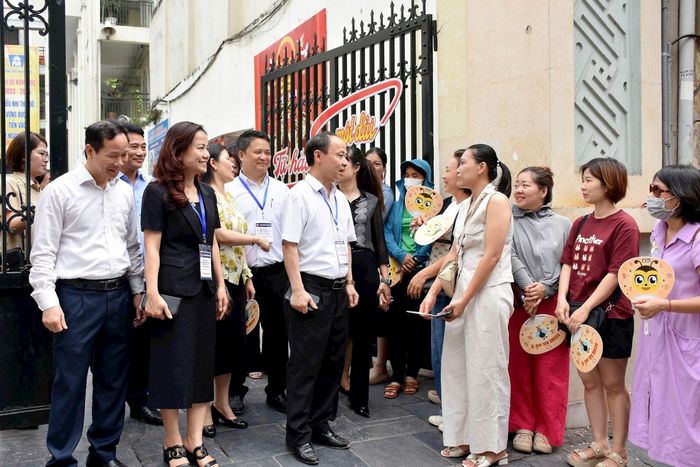 Đại diện Ban Chỉ đạo thi, tuyển sinh thành phố trò chuyện cùng phụ huynh thí sinh. Ảnh: Phạm Thảo. 