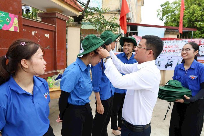 Lãnh đạo xã Đại Xuyên trao tặng mũ cho thanh niên tình nguyện tiếp sức mùa thi. Ảnh: HN