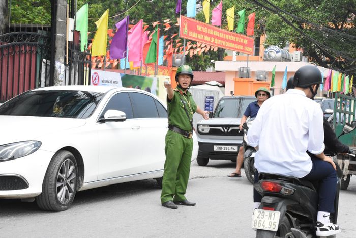Lực lượng công an xã Phù Đổng tham gia phân luồng giao thông tại điểm thi. Ảnh: PV