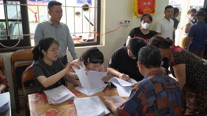 Ông Nguyễn Hữu Tiến (người đứng bên trái) Giám đốc Ban Quản lý dự án đầu tư - hạ tầng xã Chương Dương chỉ đạo công tác bồi thường. Ảnh: Duy Anh