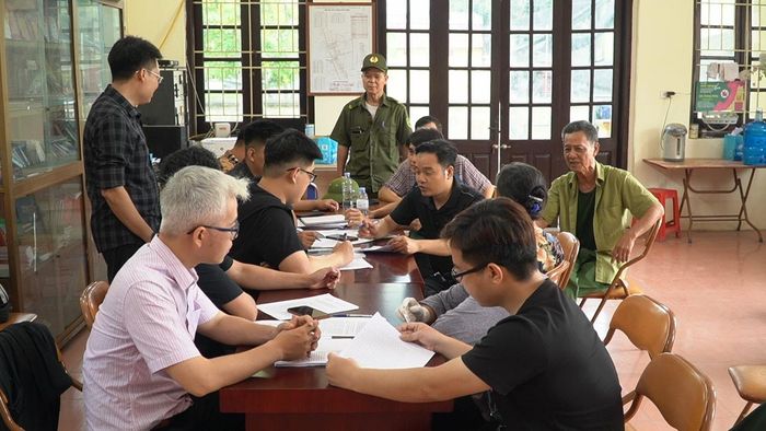 Tổ công tác hướng dẫn người dân thôn Từ Vân hoàn thiện giấy tờ liên quan đến đất trên dự án. Ảnh: Duy Anh