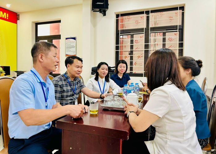 Lãnh đạo phường Hoàng Mai trao đổi với Điểm trưởng Điểm thi Trường THPT Trương Định. Ảnh: Trần Oanh.