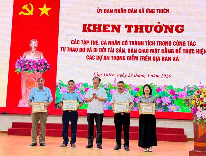 Lãnh đạo xã trao khen thưởng cho các tập thể, cá nhân có thành tích trong công tác giải phóng mặt bằng. Ảnh: Vân Nga