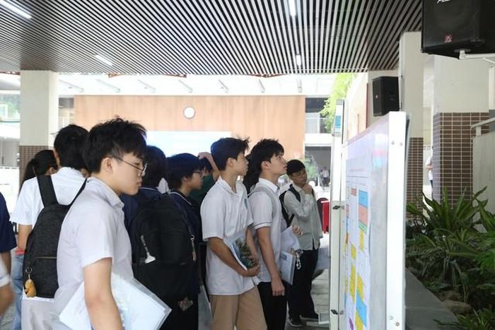 Thí sinh tập trung xem sơ đồ phòng thi và danh sách số báo danh tại bảng thông tin của nhà trường.