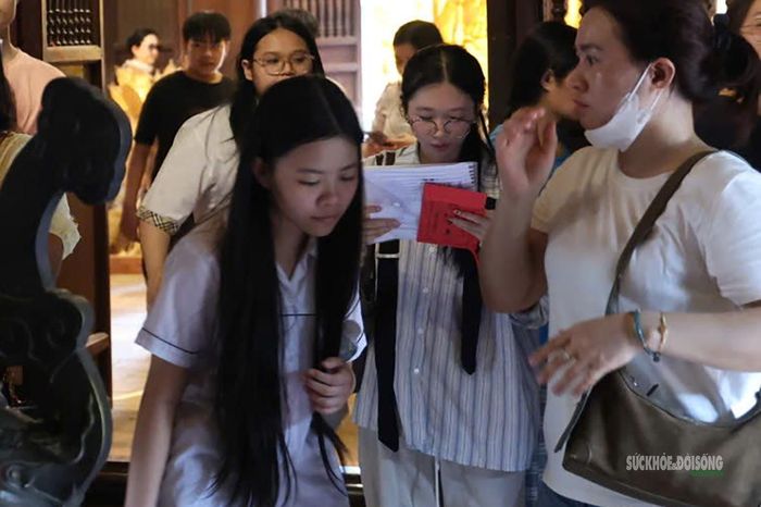 Sĩ tử mang theo giấy tờ vào khu thờ tự.
