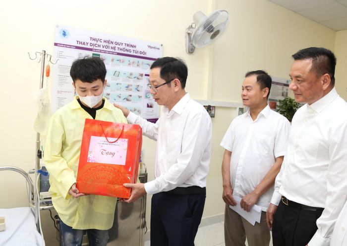 Phó Chủ tịch UBND thành phố Vũ Tiến Phụng và Giám đốc Sở Y tế Lê Minh Quang tặng học bổng cho các cháu học sinh. Ảnh: D.S.