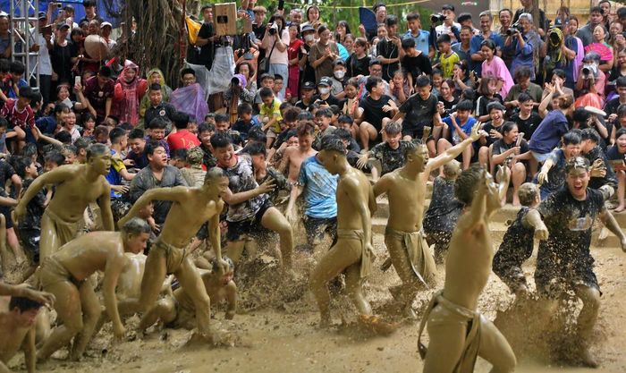 Thanh niên trong làng lao xuống sân tắm bùn chung vui cùng hai đội. 