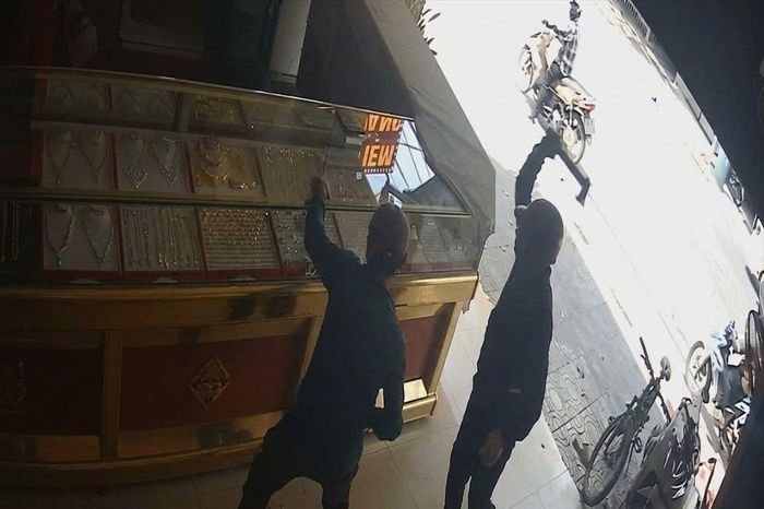  Camera ghi cảnh nhóm người xông vào tiệm vàng, dùng rìu đập bể tủ kính rồi lấy vàng tẩu thoát. Ảnh: CA 