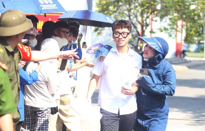  Bên ngoài điểm thi, trong điều kiện thời tiết Hà Nội nắng nóng, nhiều phụ huynh đứng chờ dưới các tán cây hoặc khu vực có bóng râm, chuẩn bị sẵn nước mát. Ảnh: VT 