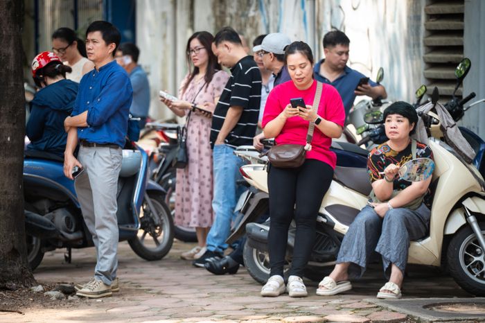  Khi cánh cổng trường khép lại, không ít phụ huynh chọn nán lại thay vì trở về nhà. Người tìm bóng râm ngồi chờ, người cầm sẵn chai nước, đồ ăn nhẹ, ô mũ để đón con sau 2 giờ thi. 