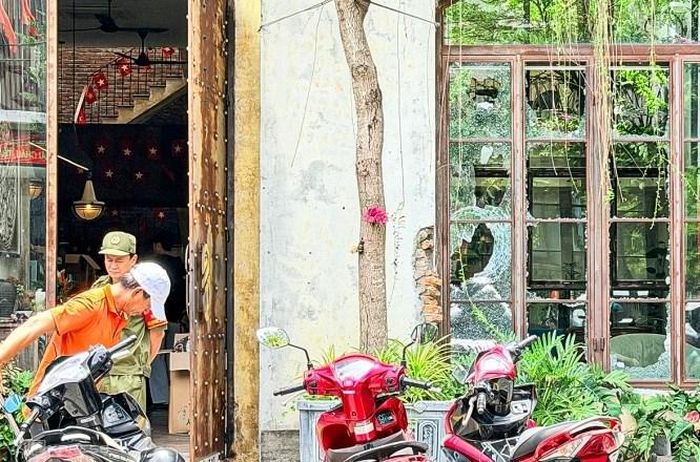Kính của quán cà phê bị người đàn ông nước ngoài đập vỡ, đến trưa 30.5 nhân viên quán vẫn đang quét dọn. Ảnh: Ngọc Trường