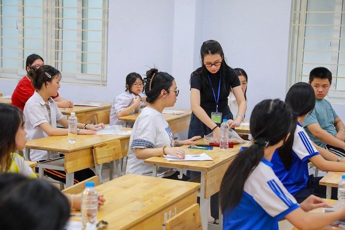 Giám thị kiểm tra đồ dùng mang theo của thí sinh phòng thi tại Điểm thi trường THPT Đoàn Kết - Hai Bà Trưng (phường Bạch Mai). Ảnh: Khánh Hòa - TTXVN