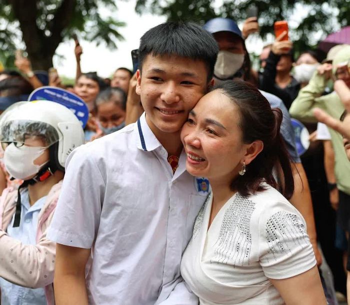 Phụ huynh vui mừng đón thí sinh sau khi hoàn thành môn thi đầu tiên tại điểm thi Trường THPT Trần Nhân Tông