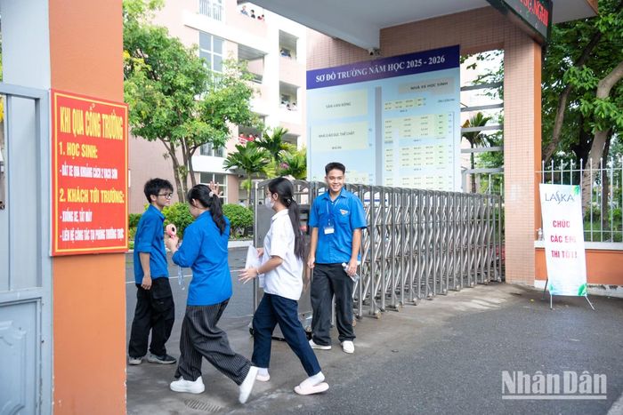 Các thanh niên tình nguyện hướng dẫn các em học sinh kiểm tra giấy tờ, dụng cụ làm bài cần thiết trước khi dẫn vào cổng trường và chỉ lối lên phòng thi.