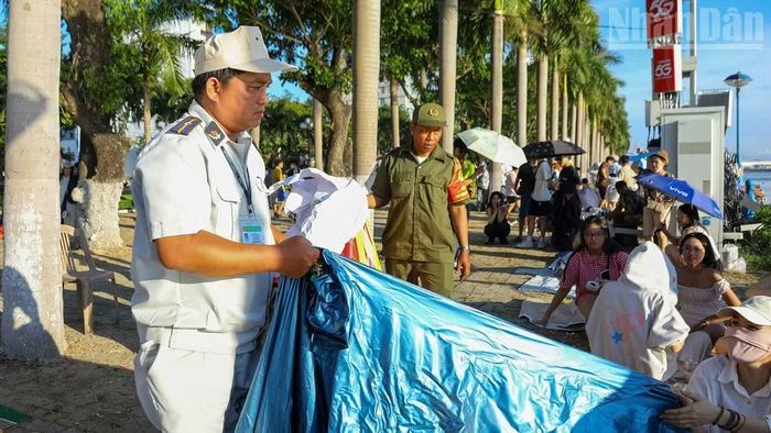 Lực lượng chức năng tiến hành nhắc nhở và dọn dẹp những tấm bạt mà người dân bày ra để giành và bán chỗ.