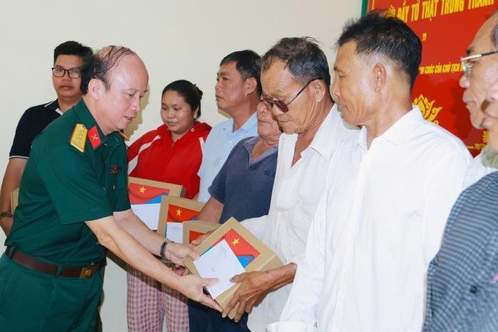 Đại tá Nguyễn Đình Chuẩn, Phó Chính ủy Bộ Tư lệnh TPHCM tặng quà cho ngư dân; ảnh: L.Trầm