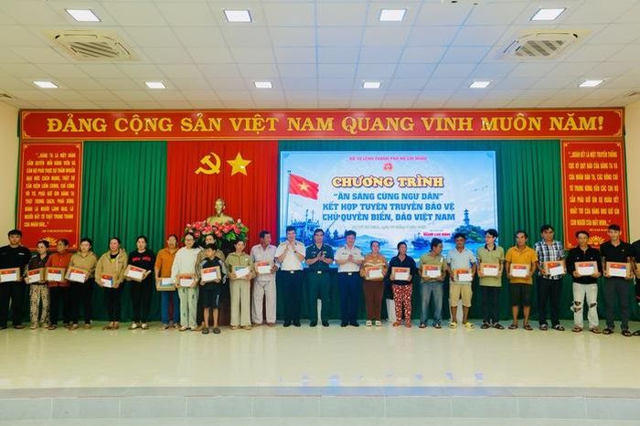 Đại diện Bộ Tư lệnh Vùng 2 Hải quân và Bộ Tư lệnh Vùng Cảnh sát biển 3 trao tặng quà cho ngư dân. Ảnh: L.Trầm