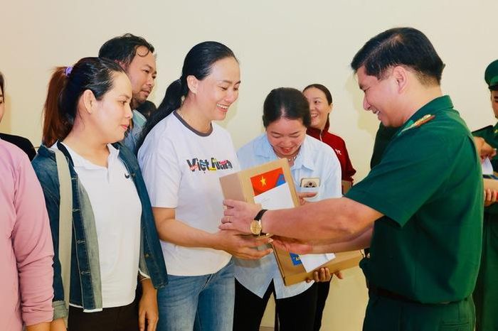 Đại tá Đỗ Vĩnh Thăng - Phó Chính ủy Bộ Tư lệnh TPHCM kiêm Chính ủy Ban Chỉ huy Bộ đội Biên phòng Thành phố trao quà cho ngư dân. Ảnh: L.Trầm