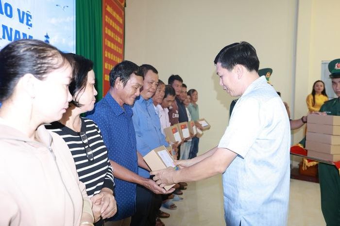 Lãnh đạo xã Phước Hải trao đến ngư dân những lá cờ Tổ quốc. Ảnh: L.Trầm