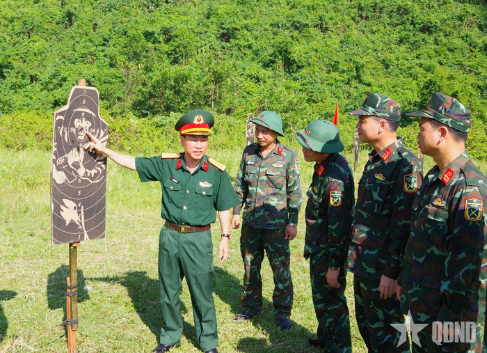 Đại tá Nguyễn Văn Tấn, Phó chủ nhiệm Chính trị Quân đoàn 12 (ngoài cùng bên trái) kiểm tra kết quả thực tế trên bia bắn súng tiểu liên AK bài 1. 