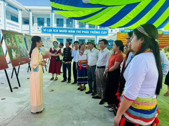 Các đại biểu nghe hướng dẫn viên giới thiệu về những hình ảnh, tư liệu của người Co.