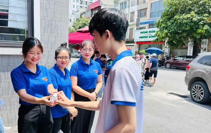 Thanh niên tình nguyện tặng nước uống cho thí sinh tại điểm thi Trường THCS Nguyễn Như Uyên (phường Yên Hòa).
