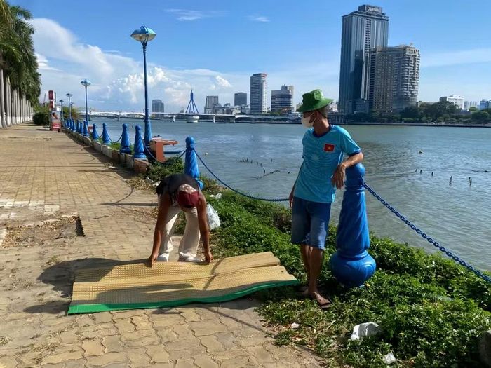 Dưới thời tiết nắng nóng, nhiều người dân và du khách vẫn kiên nhẫn chờ đợi nhiều giờ để có vị trí thuận lợi xem pháo hoa bên sông Hàn.
