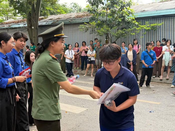 Lực lượng thanh niên tình nguyện phát nước, khăn ướt và động viên thí sinh trước giờ thi